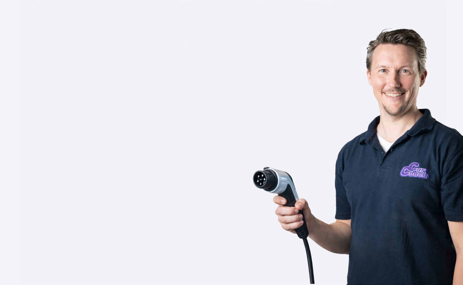CarCoach Johannes mit Elektro-Ladestecker in der Hand