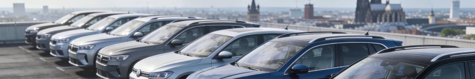 Gebrauchtwagen Modelle auf Parkplatz in Köln mit Dom in Hintergrund