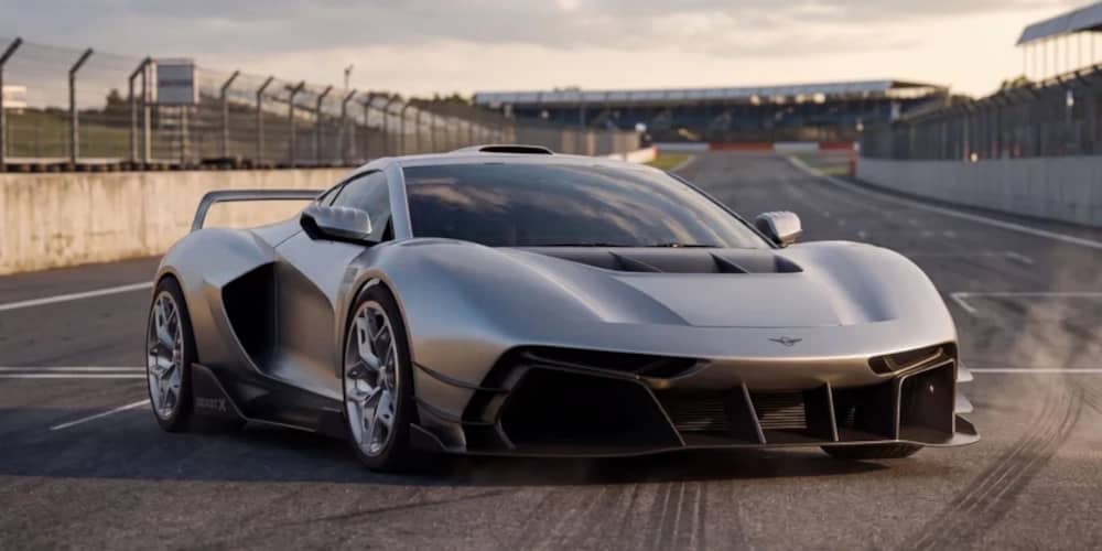 Ein silberner Rezvani Beast X Sportwagen steht auf einer Rennstrecke. Auffällig sind der große Heckflügel, aggressive Lufteinlässe und der Schriftzug „BEAST X“ am Seitenschweller.