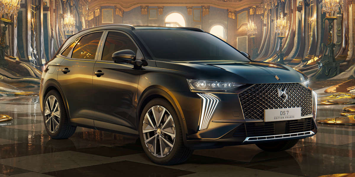 Das Bild zeigt einen dunklen DS 7, Edition France, SUV in einem opulenten, goldenen Palastambiente. Das Auto steht auf einem Schachbrettmuster auf dem Boden. Der Fokus liegt auf dem Fahrzeug, welches luxuriös und elegant wirkt.