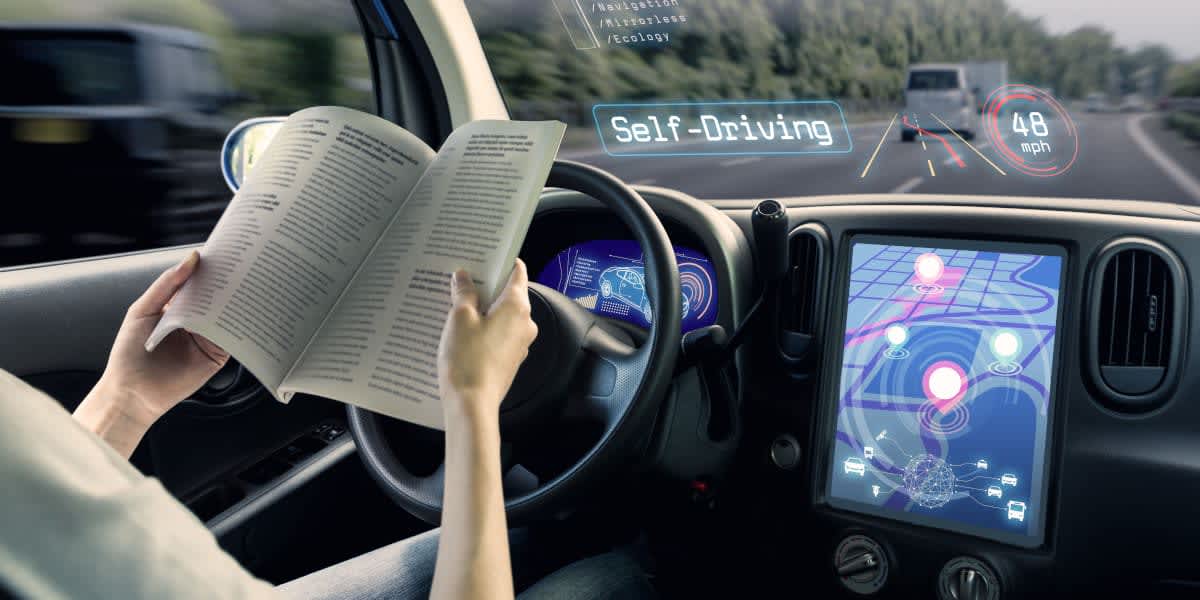 Grafik einer Person die am Steuer eines autonomen Fahrzeugs liest