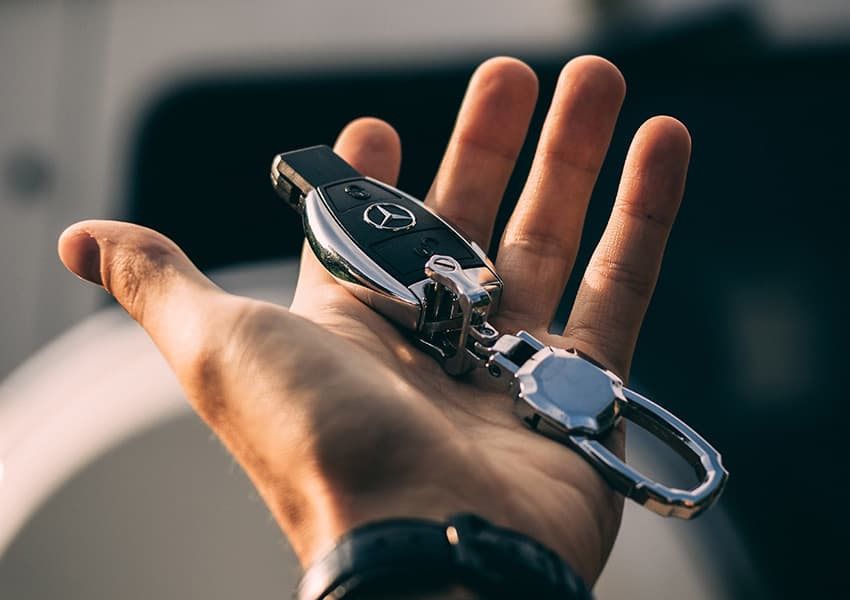 Eine ausgestreckte Hand in der ein Autoschlüssel liegt