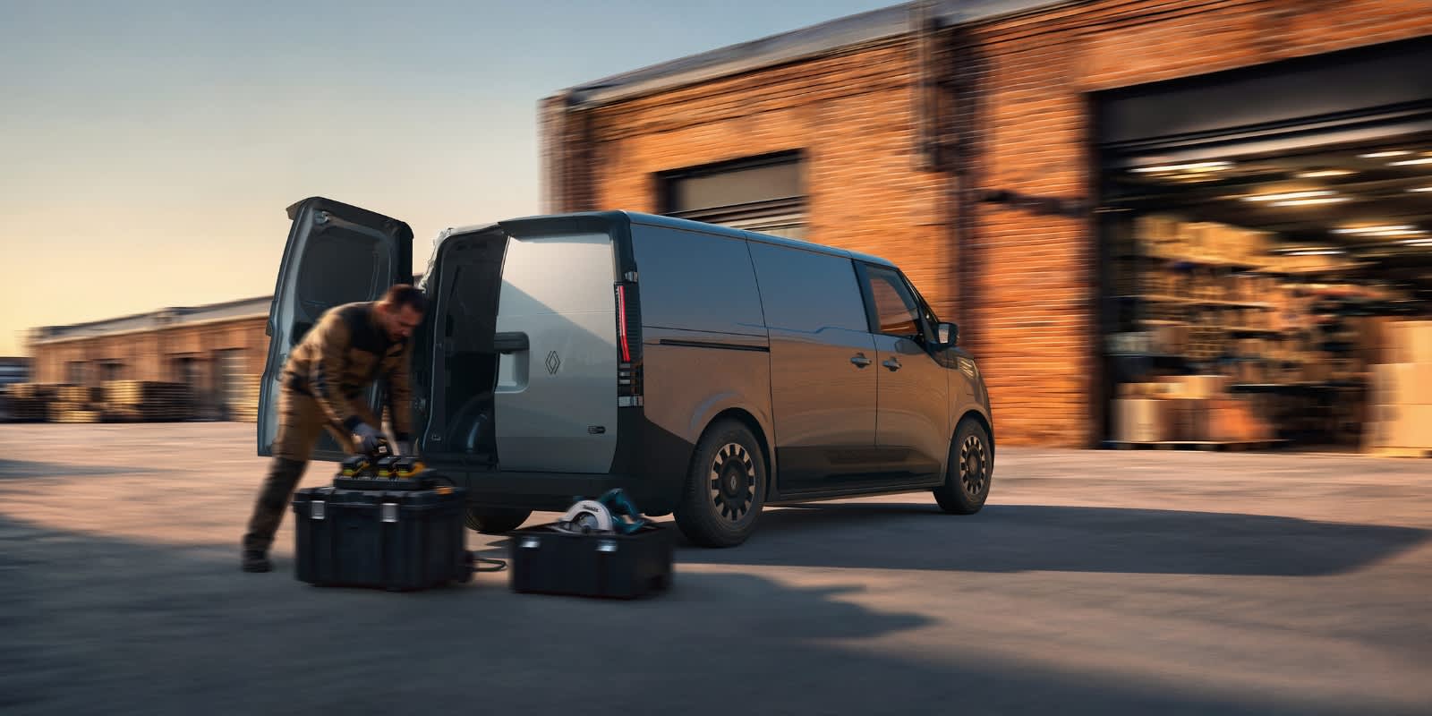 Renault Trafic E-Tech Van in schwarz von hinten mit Mann der etwas in den Kofferraum lädt.
