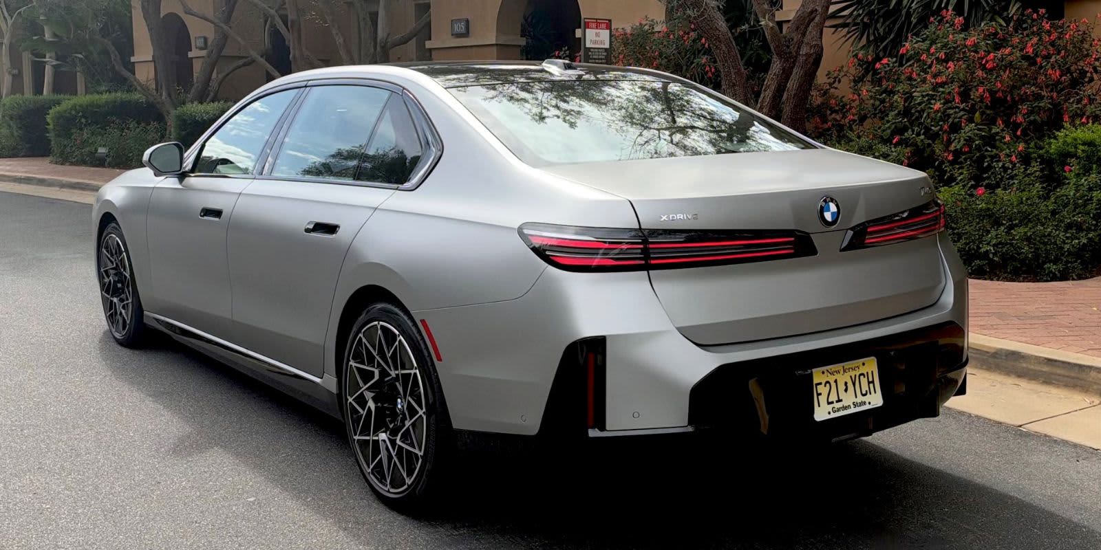 Ein silberner Bmw 7er von hinten auf einer Straße.