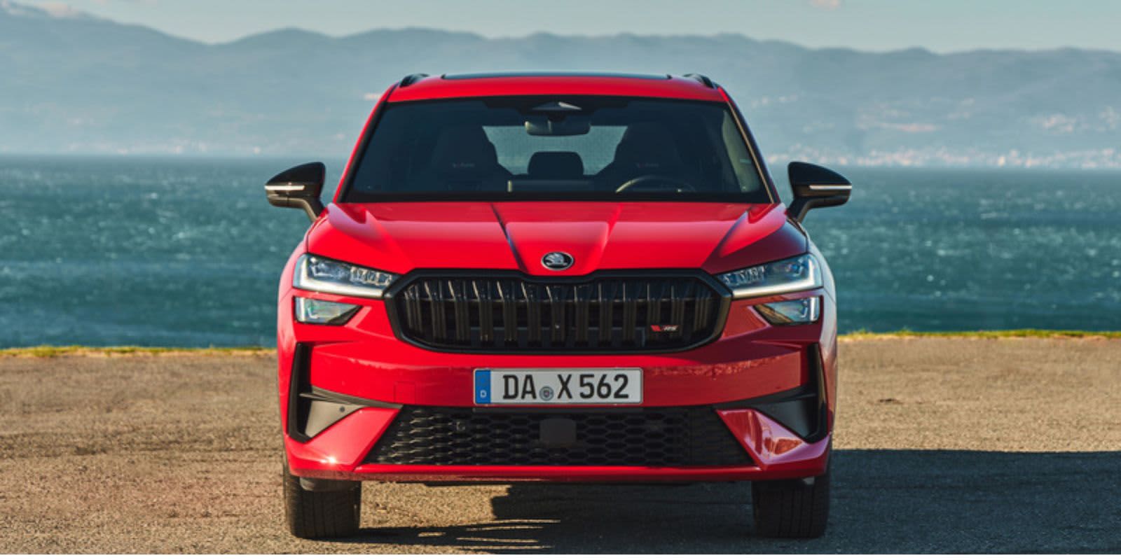 Ein roter Skoda Kodiaq RS frontal, im Hintergrund erkennt man das Meer.