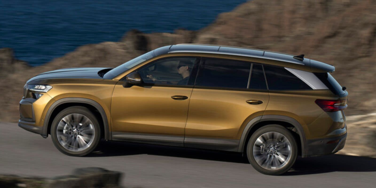 Goldener Skoda Kodiaq seitlich fahrend.