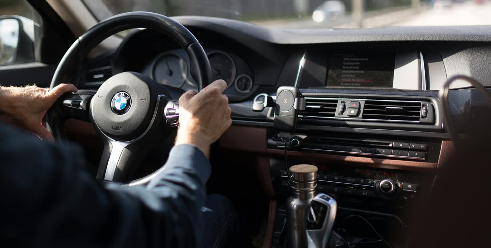 Mann mit Händen am BMW Lenkrad