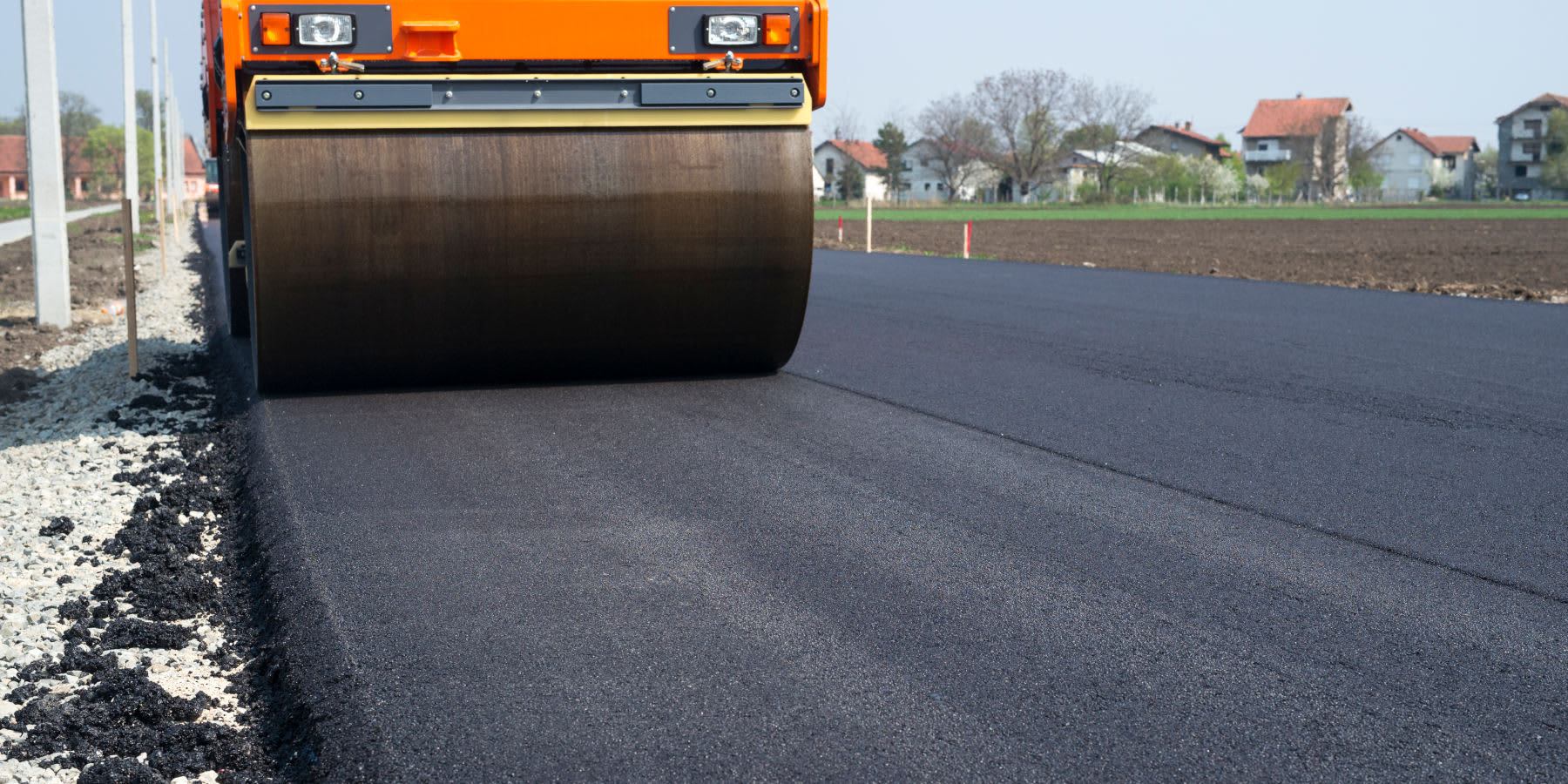 Flüsterasphalt: Dampfwalze bringt Teer auf eine Straße auf