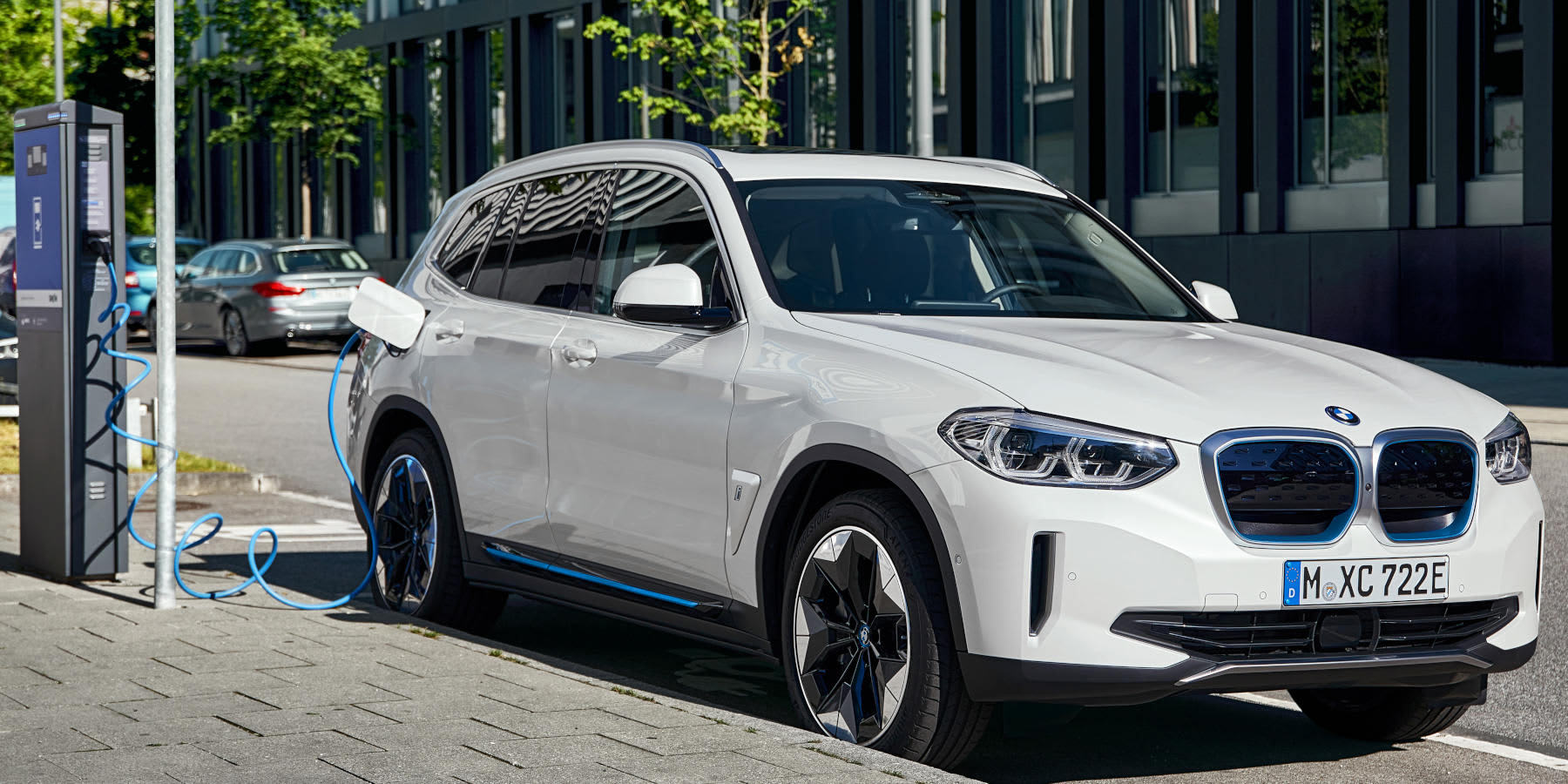 Weißer BMW iX3 an einer Ladesäule beim Aufladen
