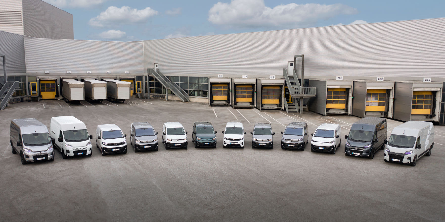 Viele Stellantis Transporter in einer Reihe aufgestellt vor einer Lagerhalle