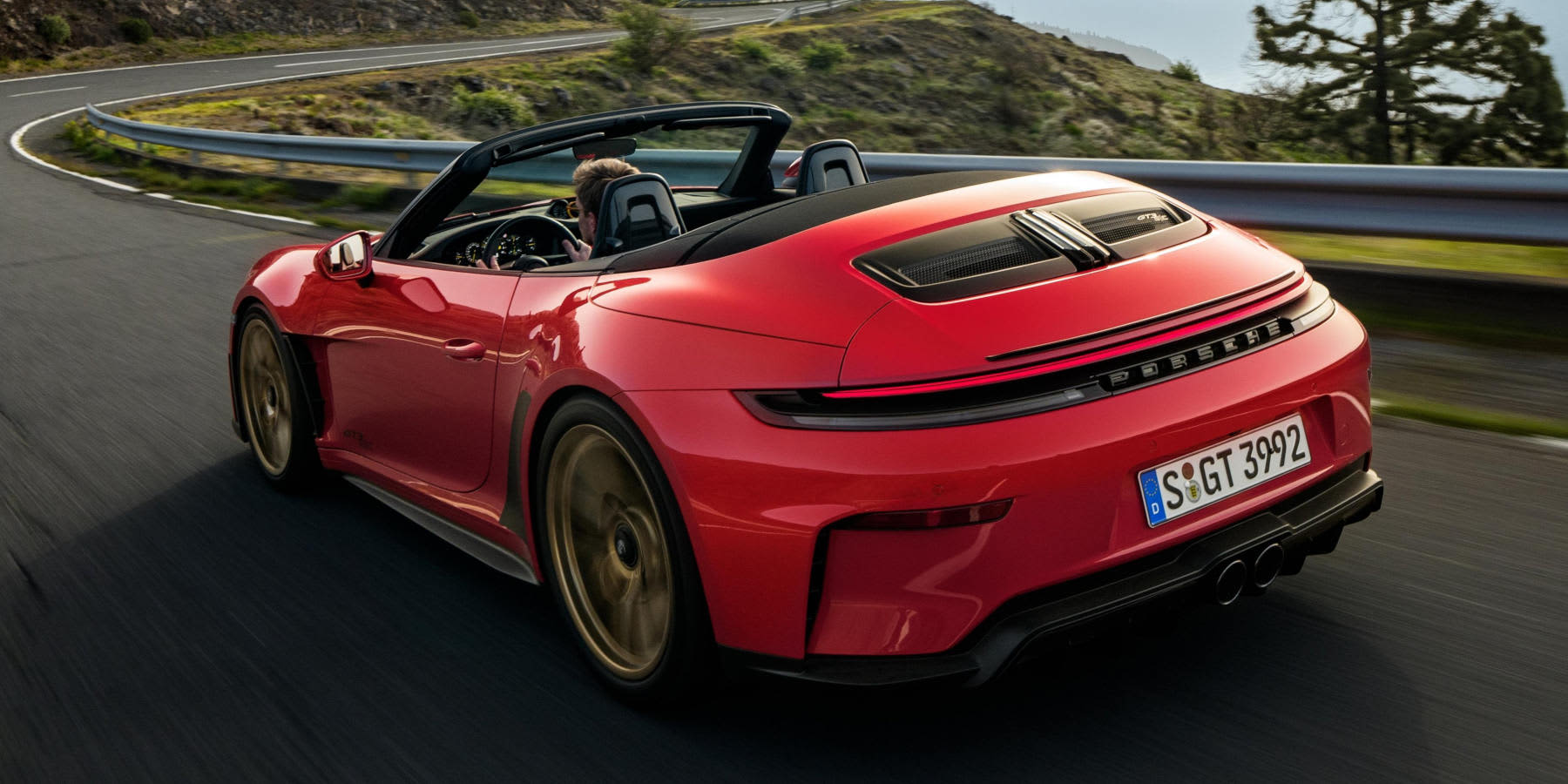 Roter Porsche 911 GT3 S/C fährt auf einer Straße mit offenem Verdeck: Heckansicht