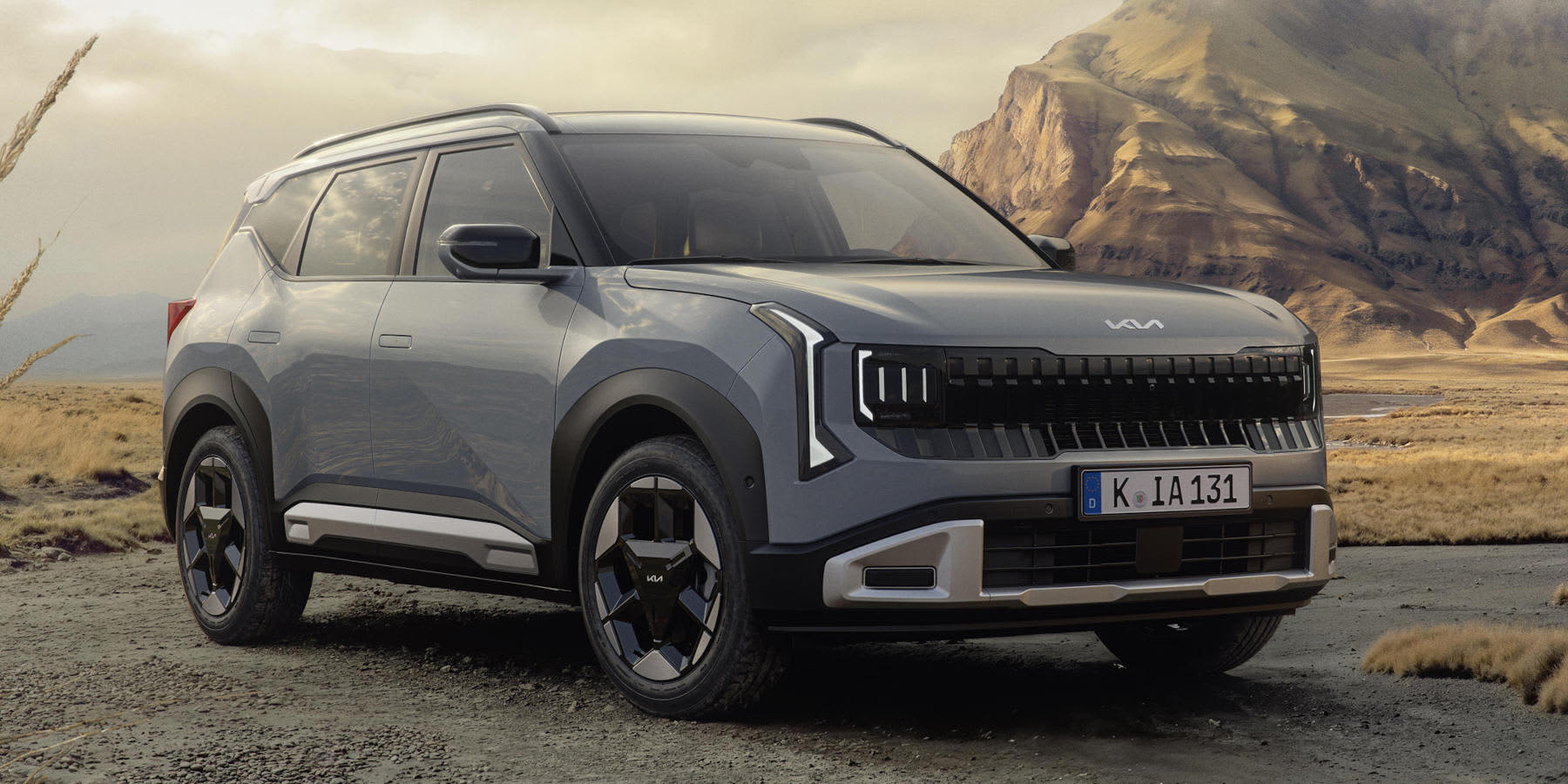 Ein grauer Kia Seltos steht in einer kargen Berglandschaft. Das SUV zeigt das neue Kia-Markengesicht mit markanter Lichtsignatur, futuristischen Felgen und einem deutschen Kennzeichen.