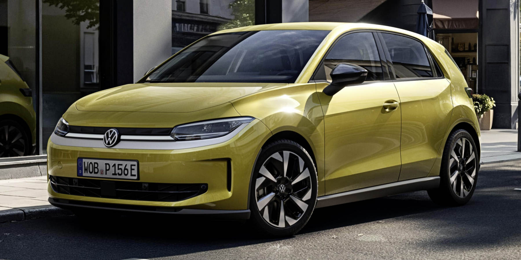 Ein limettengelber VW ID. Polo steht am Straßenrand vor einer Glasfront. Markant sind die durchgehende LED-Lichtleiste vorne und die zweifarbigen Alufelgen.