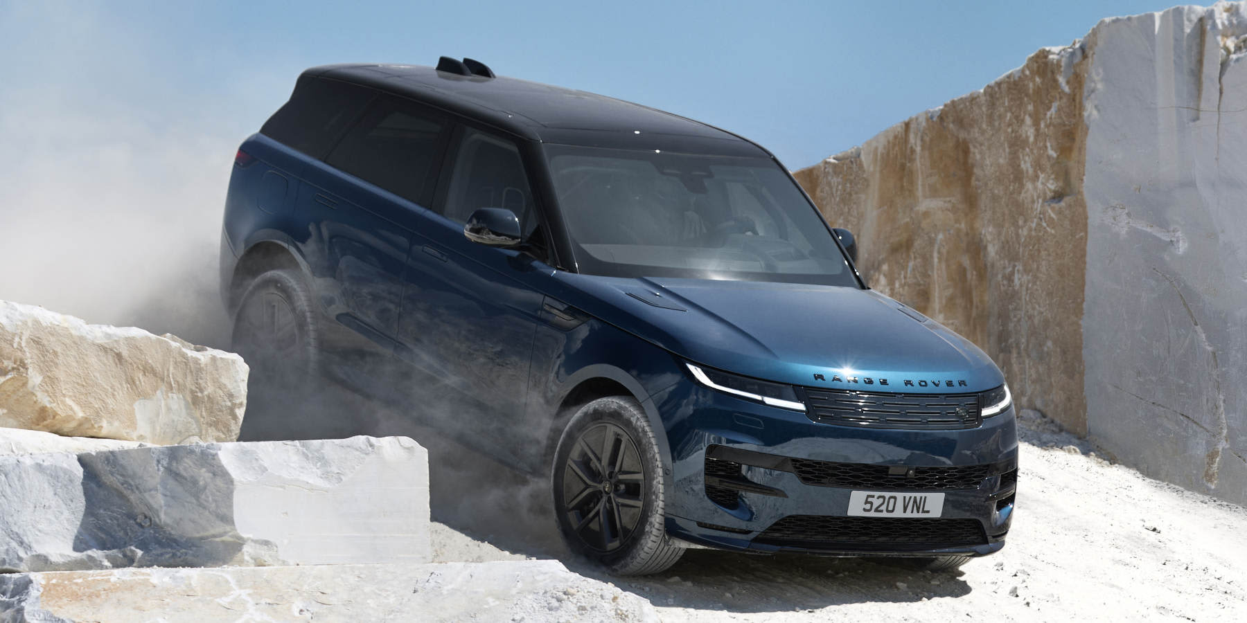 Land Rover Range Rover Sport Electric fährt staubige Abfahrt hinunter.