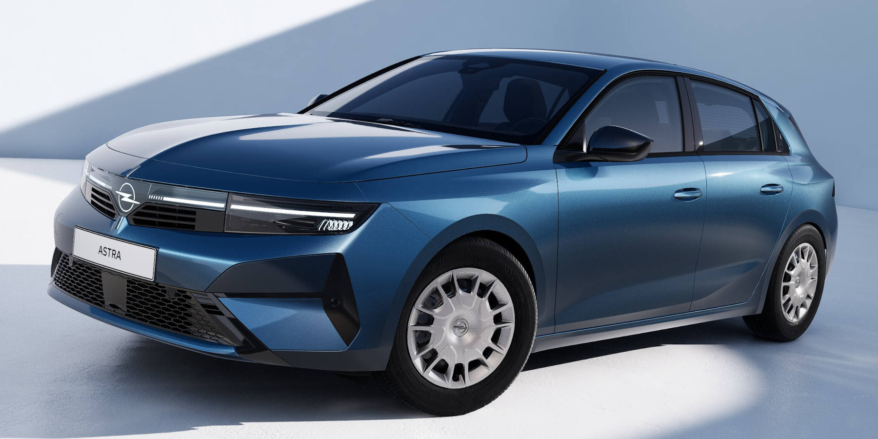 Ein blauer Opel Astra zeigt sich vor hellem Studiohintergrund. Ins Auge fallen die schwarze Vizor-Frontpartie, schmale LED-Scheinwerfer und silberne Vielspeichenfelgen.   