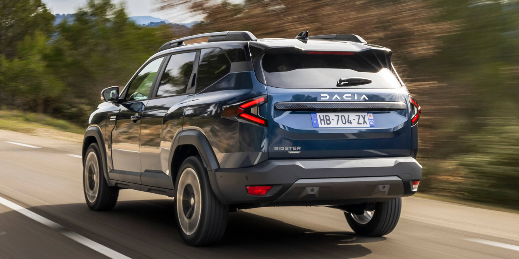 Dacia Bigster Heck schraäg in Fahrt auf einer Straße