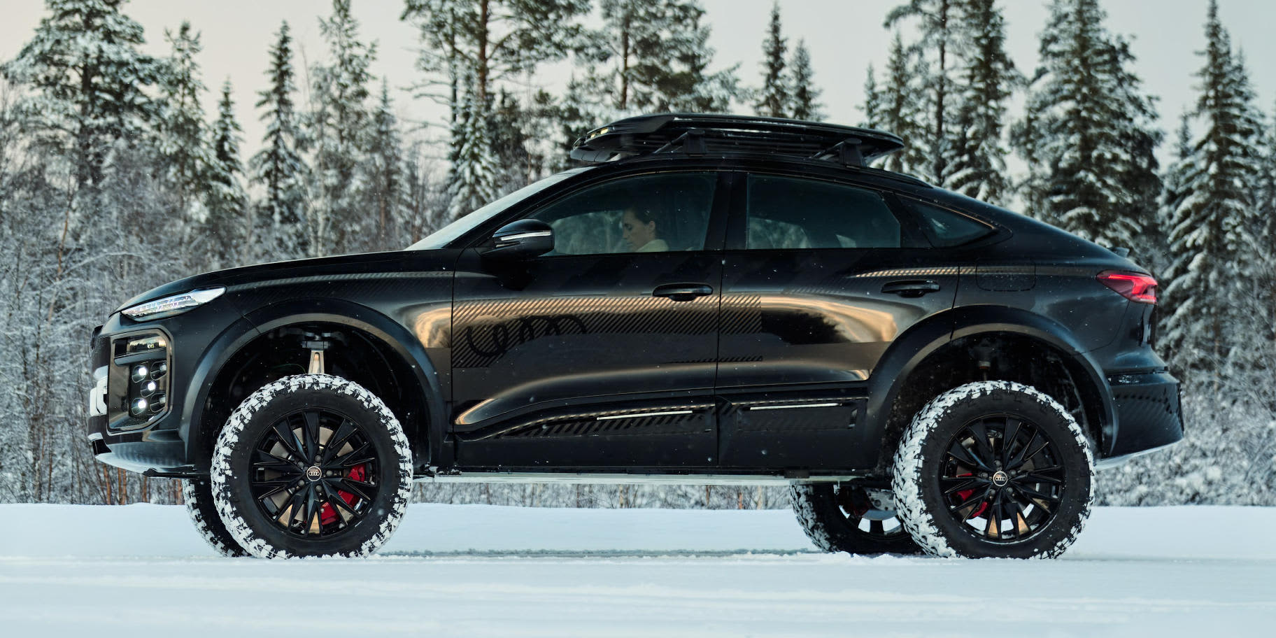 Audi Q6 e-tron Offroad Concept von der Seite im schneebedeckten Wald