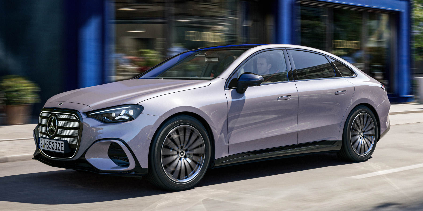 Neue elektrische Mercedes-Benz C-Klasse in Silbergrau auf einer Straße in einer Stadt