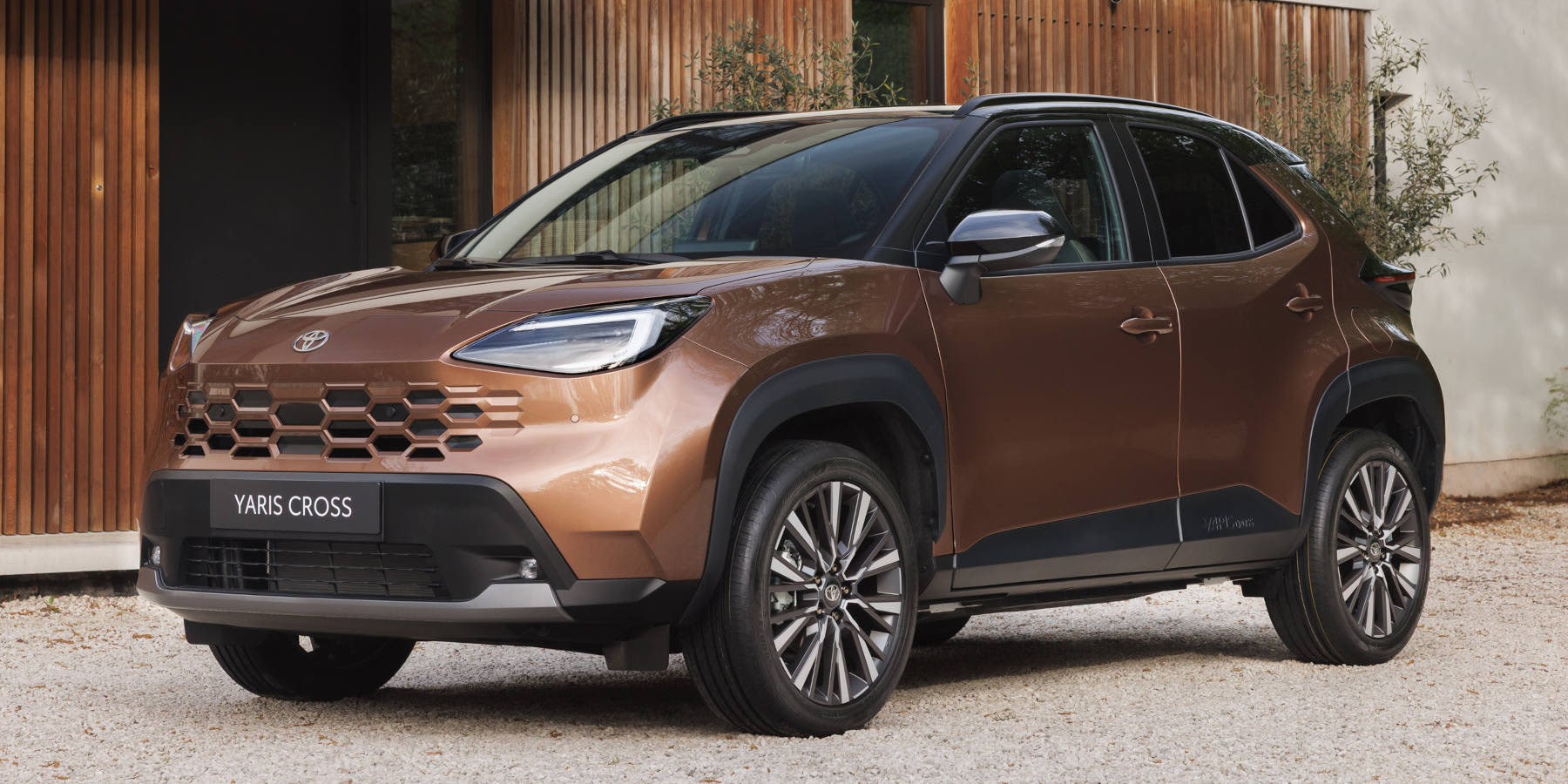 Toyota Yaris Cross in Bronze-Farbe vor einem Haus