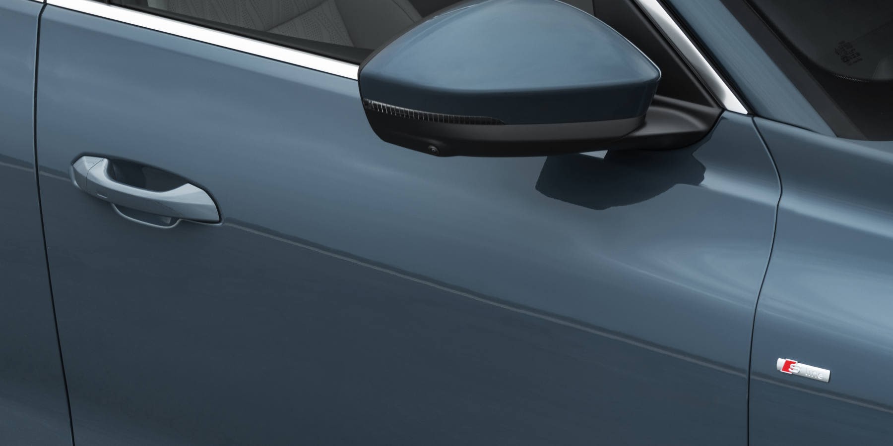 Ein Detailausschnitt eines blaugrauen Audi Q7 zeigt den Außenspiegel, die Fahrertür samt Griff und ein „S line“-Emblem auf dem vorderen Kotflügel. (KI-generiert)